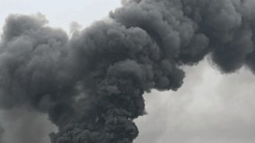 Thick black smoke rising into the sky from an unknown fire or explosion. Could indicate wildfire, industrial accident, or large-scale burning. Concept of danger, pollution, and disaster. - Powered by Shutterstock - Get 15% off with code: PIKWIZARD15