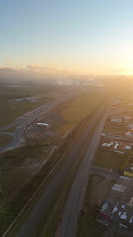Drone footage of Mogi das Cruzes entrance at dawn, São Paulo, Brazil, showing soft sunrise light over the metropolitan skyline and roads
