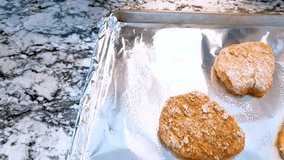 Three pieces of raw dough are spaced on a foil-lined tray ready to bake. The overhead view highlights the shape and texture of the unbaked pastries under soft kitchen light. - Powered by Shutterstock - Get 15% off with code: PIKWIZARD15