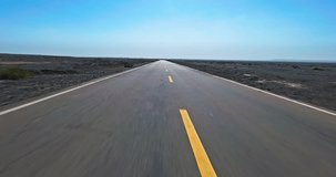An straight asphalt highway through vast and barren desert landscape under blue sky - Powered by Shutterstock - Get 15% off with code: PIKWIZARD15