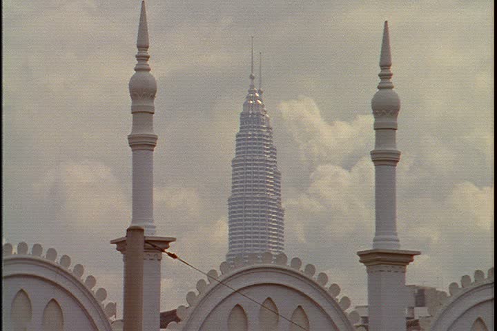 KUALA LUMPUR - OCTOBER 25, 1999: MS white minarets of the Kuala Lumpur railway station. Between the minarets are the tops of the Petronas Towers.