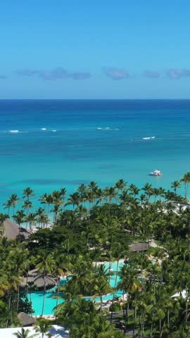 Coastline with resorts and hotels. Tropical destination for travel and summer holidays. Aerial view from drone. Vertical footage