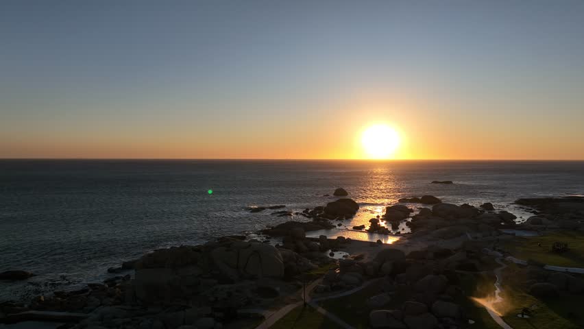 Sunset over the sea in Cape Town with rocks and tidal pool
