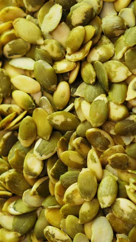 Pumpkin seed background. Closeup. Nobody. Top view. Rotate. Vertical footage