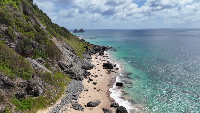 Sweeping aerial panorama of Fernando de Noronha showing rugged coastline, multiple turquoise bays and rocky islets a dramatic island mosaic from above.