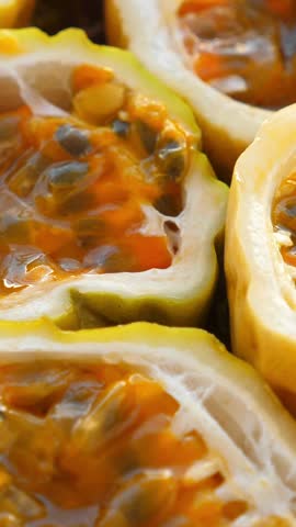 Passion fruit background with half cut chinola. A lot of sliced maracuja. Tropical fruits backdrop. Vertical footage