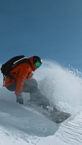 Snowboard rider riding down fresh powder during sunny day, Alpine scenery. Super slow motion at 1000 fps.