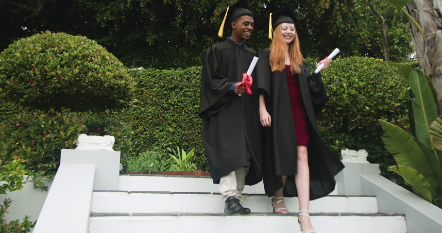 Diverse graduates descending on steps, marking milestone by shaking hands and holding diplomas. Celebration, achievement, academia, friendship, outdoor, vibrant, success