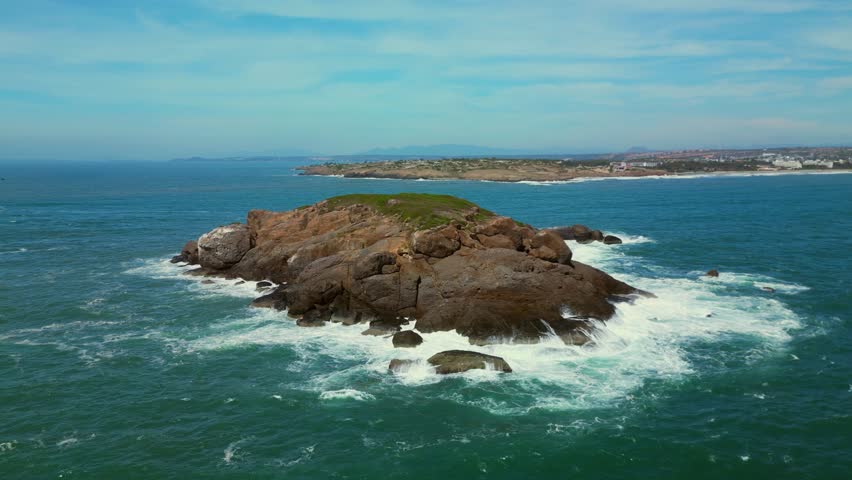 Aerial top view of waves crashing on rocks in a blue ocean. Sea waves on a beautiful beach aerial view a 4k. Bird