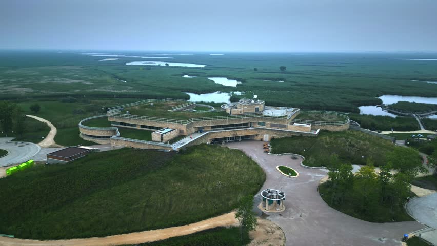 Foggy daytime hyperlapse shows eco modern centre amid green wetlands