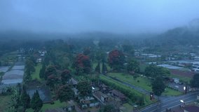 Traditional Balinese split stone gates rising against a lush garden with green lawns, tropical trees, and vibrant red flowers, surrounded by mystical morning mist - Powered by Shutterstock - Get 15% off with code: PIKWIZARD15