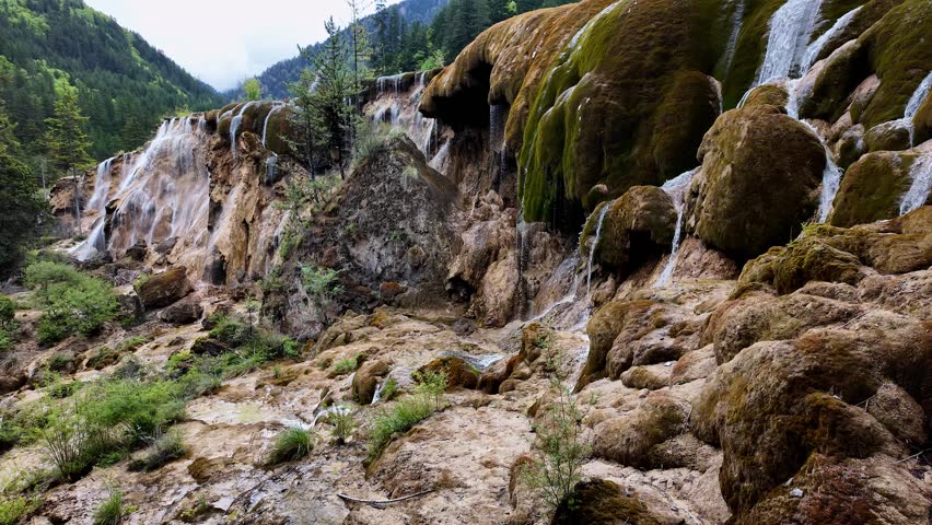 Jiuzhaigou, China: Panoramic footage of the famous Pearl Shoals waterfall in Jiuzhaigou in the mountain of Sichuan in China on a cloudy spring day after the rainy season. 