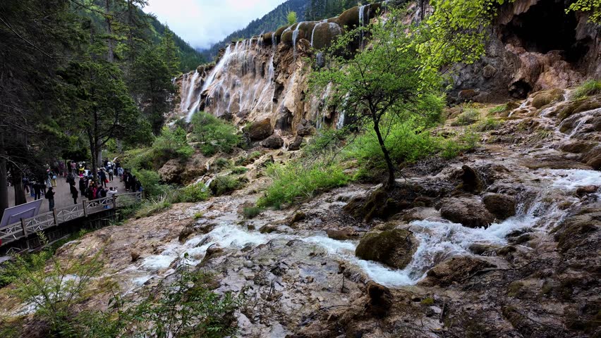 Jiuzhaigou, China: Panoramic footage of tourist who enjoy the view of the famous Pearl Shoals waterfall in Jiuzhaigou in the mountain of Sichuan in China