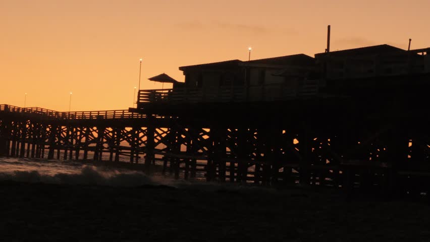 beautiful orange yellow golden hour sunset over pacific beach san diego california with crystal pier dock, southern california summer