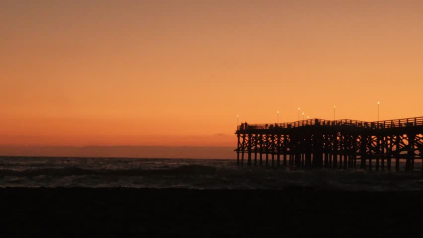 beautiful orange yellow golden hour sunset over pacific beach san diego california with crystal pier dock, southern california summer