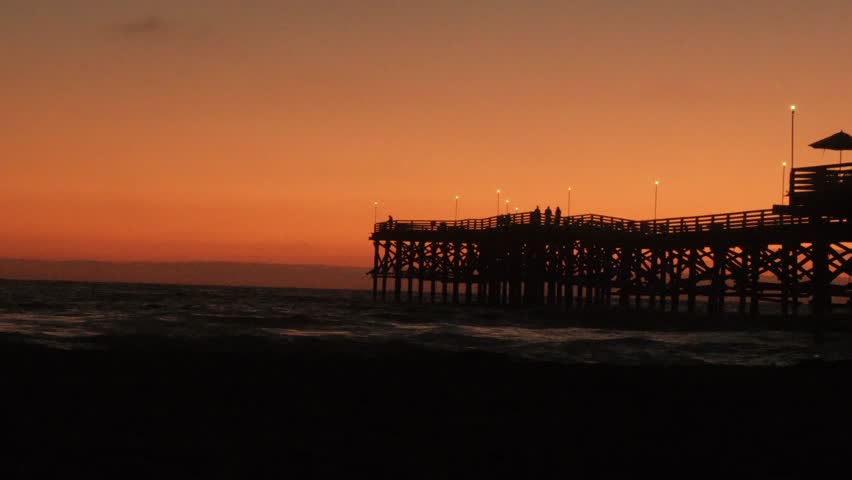 beautiful orange yellow golden hour sunset over pacific beach san diego california with crystal pier dock, southern california summer