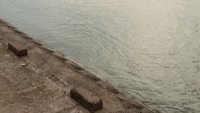 Weathered concrete embankment along the shoreline. Minimalist view of a stone pier next to calm, rippling water. - Powered by Shutterstock - Get 15% off with code: PIKWIZARD15