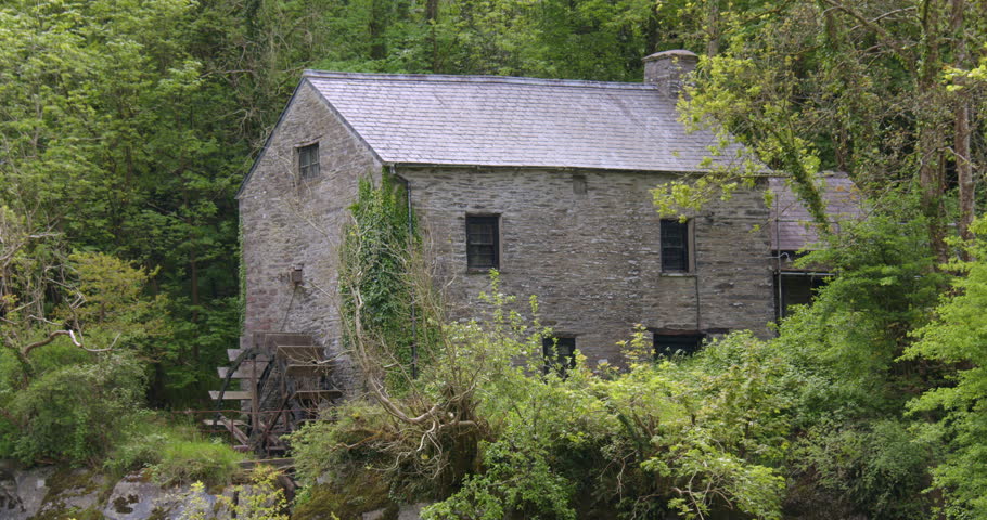 Wide shot of the 17th century flour mill at Cenarth Falls on the river Teifi