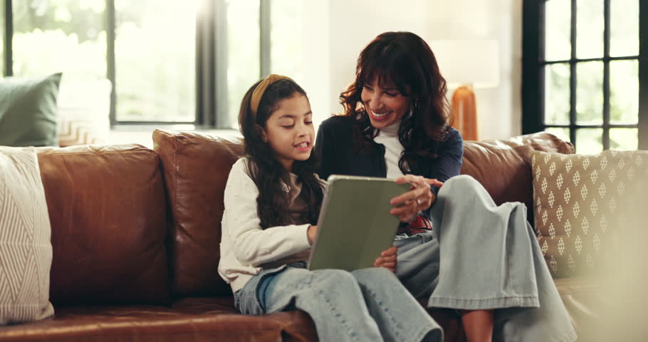 Tablet, conversation and mother with child on sofa for elearning, education or online game. Happy, bonding and mom with girl kid on technology for gaming website together in living room in home.