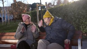 Elderly couple exchanging a christmas gift on a park bench, sharing a tender moment of love and affection - Powered by Shutterstock - Get 15% off with code: PIKWIZARD15