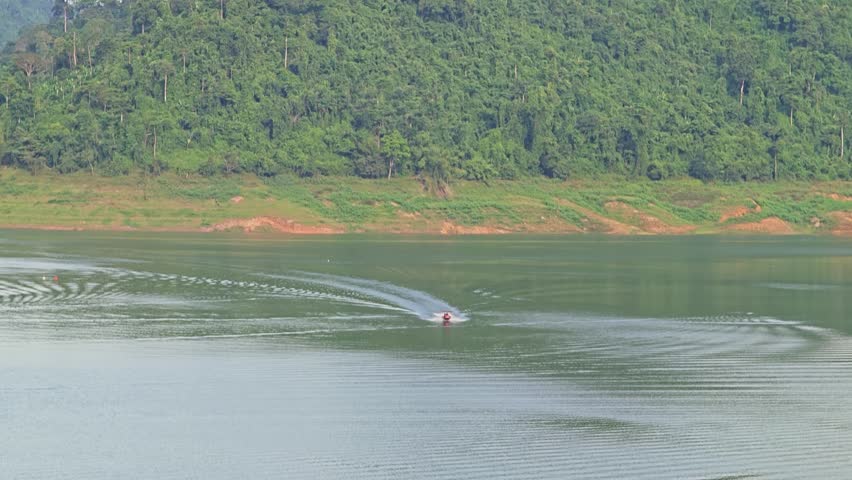 Boat in lake and dam from aerial view.