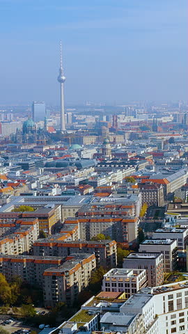 Breathtaking 4K aerial vertical video footage of Berlin's iconic skyline : the soaring Fernsehturm TV Tower, majestic Berliner Dom above Mitte blended historic and modern architecture, autumn foliage.