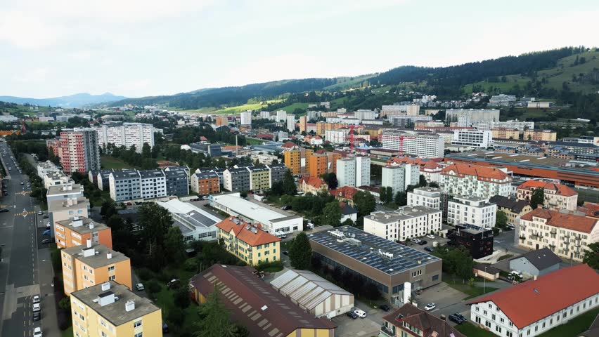 Aerial view of buildings, parks, and roads creating a vibrant tapestry under a cloudy sky, showcasing the urban landscape, La Chaux-de-Fonds, Neuchâtel, Switzerland.