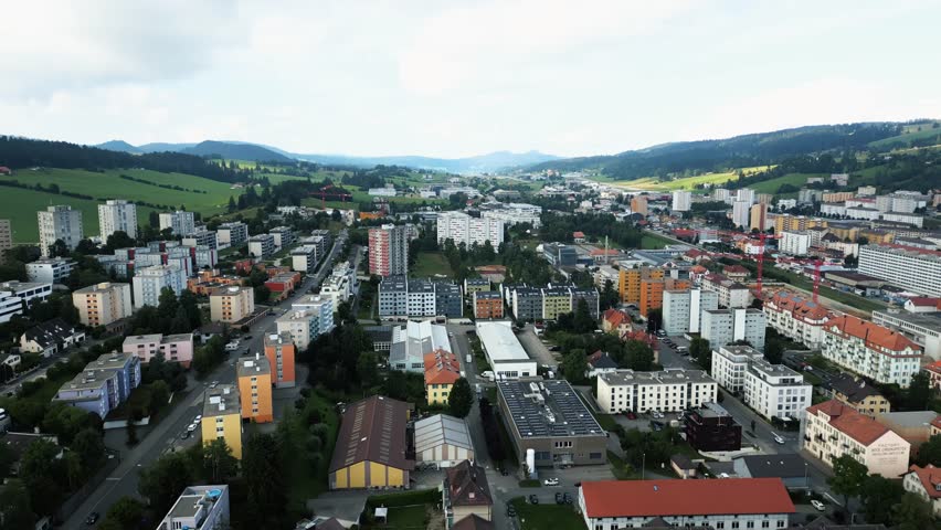 Aerial view of buildings interspersed with roads, offering a glimpse of urban life nestled in a valley, La Chaux-de-Fonds, Neuchâtel, Switzerland.