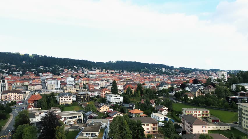 Aerial view of the buildings and greenery with contrasting red roofs creating an artistic and scenic view, La Chaux-de-Fonds, Neuchâtel, Switzerland.