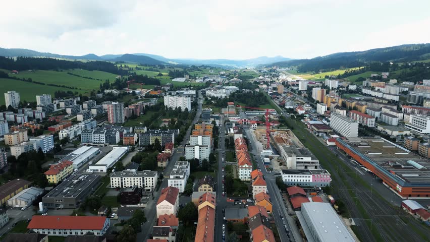 Aerial view of the cityscape showcasing buildings and roads, contrasted against the distant green hills, La Chaux-de-Fonds, Neuchâtel, Switzerland.