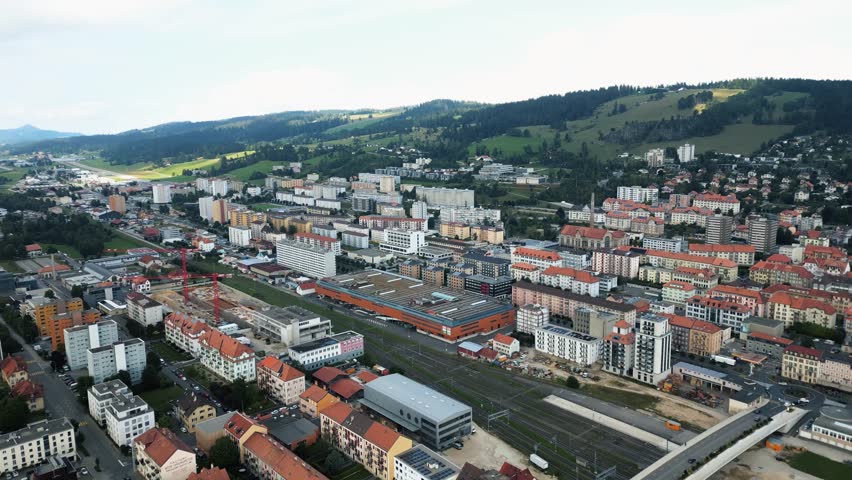 Aerial view of the city, with buildings standing in contrast to the green hills, creating a beautiful cityscape, La Chaux-de-Fonds, Neuchâtel, Switzerland.
