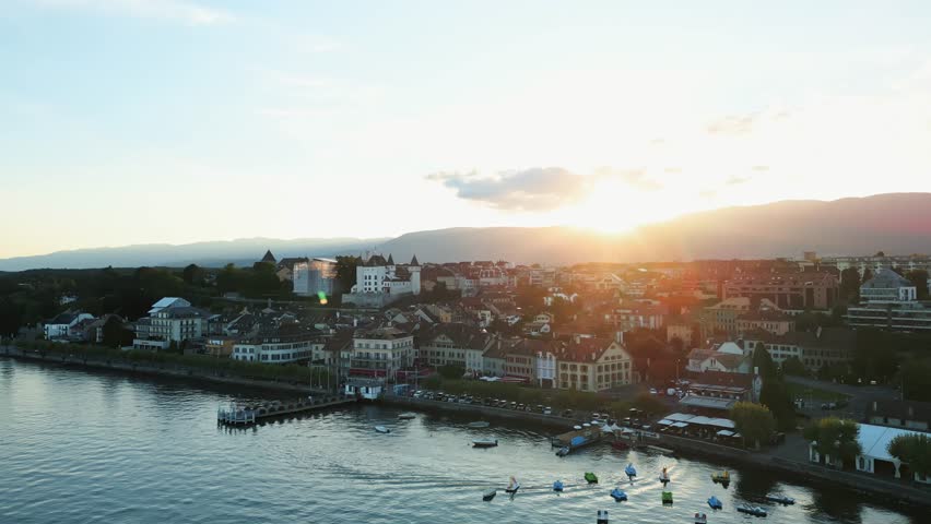 Aerial view of boats dotting the serene waters of Lake Geneva, with the city