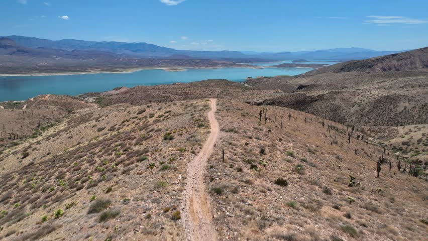 Aerial view of the serene Theodore Roosevelt lake nestled amongst the arid landscape and distant mountain ranges, Theodore Roosevelt, Arizona, United States.