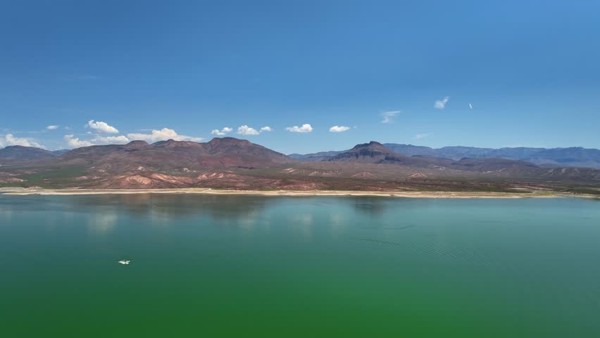 Aerial view of Theodore Roosevelt lake reflecting the sky, contrasting with the arid landscape and the mountains, Theodore Roosevelt lake, Arizona, United States.