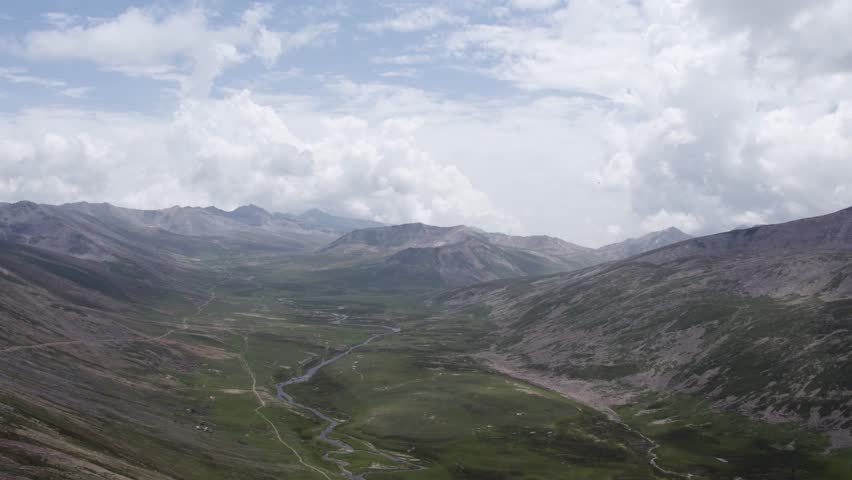 Babusar Pass with winding river, green valley, and towering mountains. Gilgit, Kashmir, Pakistan