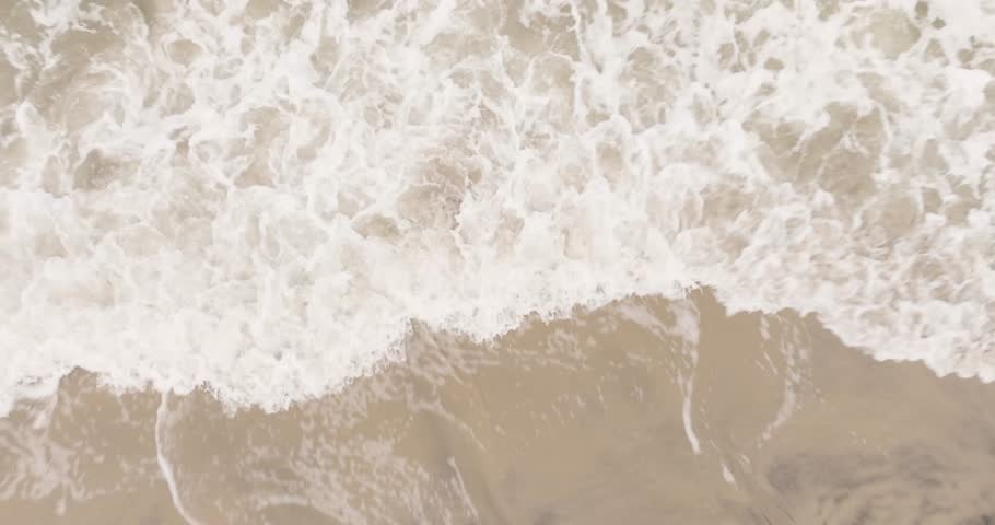 Aerial view of ocean waves crashing onto the sandy beach of Ocean City NJ