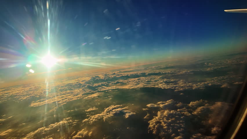 Scenic View of Sunrise Above Clouds from Airplane Window