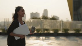 Portrait of happy Asian woman with coffee to go and laptop walks along sunset street. Female entrepreneur with positive attitude carries computer and cup to office in city - Powered by Shutterstock - Get 15% off with code: PIKWIZARD15