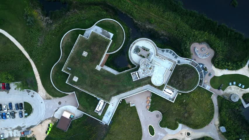 Overhead drone frames circular eco building with grass roof