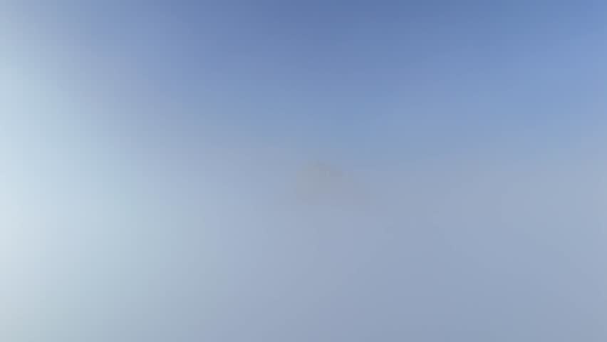 Aerial of Lion’s Head mountain in Cape Town, South Africa, appearing from the clouds surrounded by mist with only the peak emerging above the fog