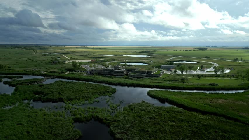 Sunlight breaks through clouds over eco centre and summer wetlands