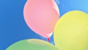 Vibrant balloons gently move against the bright blue sky, shifting positions as camera gets closer, revealing colorful surfaces glowing in natural sunlight - Powered by Shutterstock - Get 15% off with code: PIKWIZARD15