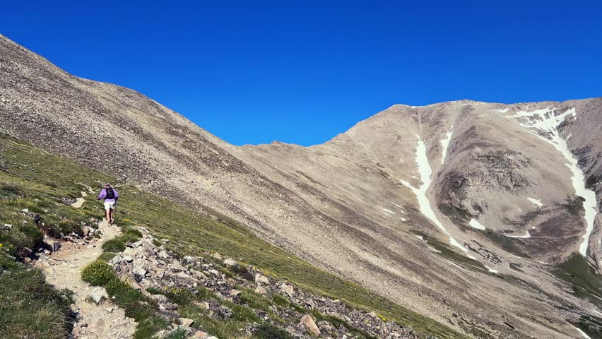 Hiker Mt Mount Princeton hiking trail 14er spring summertime Buena Vista Salida Colorado Sawatch Range melting snow fields Rocky Mountains blue clear sky morning windy breeze summit static