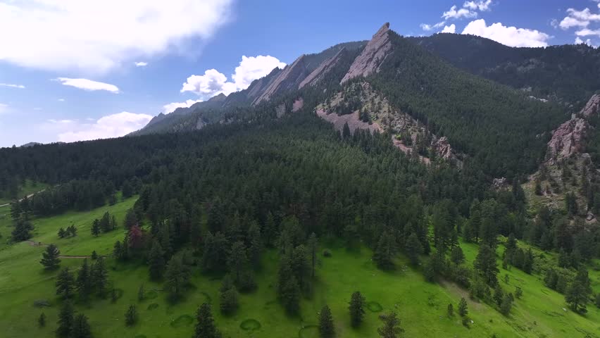 Spring summer morning blue sky Flatirons Chautauqua Park Boulder Colorado aerial drone hiking trail wildflowers Green Flatirons Mountain front range Rocky Mountains Royal Arch Shanahan Ridge Trail up