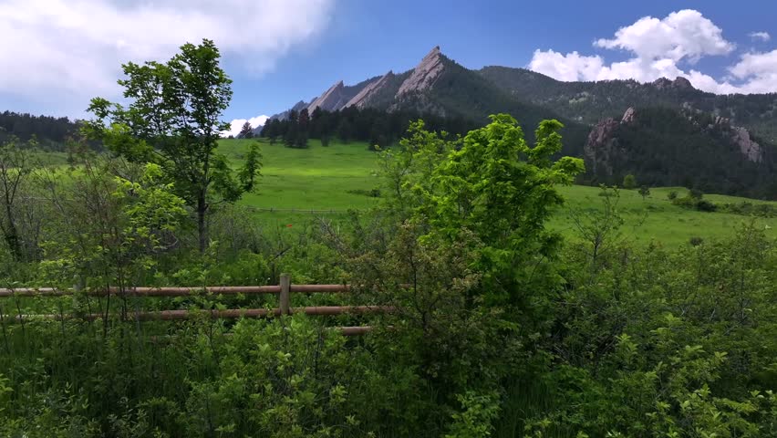Spring summer morning blue sky fFlatirons Chautauqua Park fence Boulder Colorado aerial drone Shanahan Ridge hiking trail Green Flatirons Mountain front range Rocky Mountains Royal Arch upwards