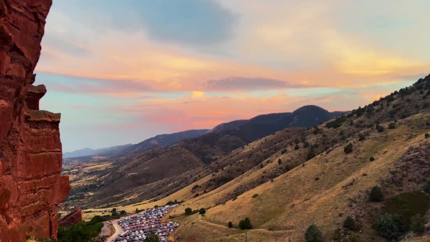 Summer sunset front range Morrison Colorado Red Rocks Amphitheater Park golden hour concert venue orange vibrant clouds foothills Evergreen Golden parking lot static shot