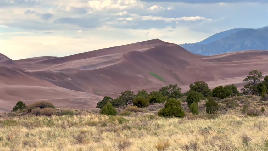 The Great Sand Dunes National Park Sangre de Cristo range Rocky Mountains spring summer raining sunny cloudy Colorado unique magical large amounts of sand dune hills windy landscape Crestone Needle