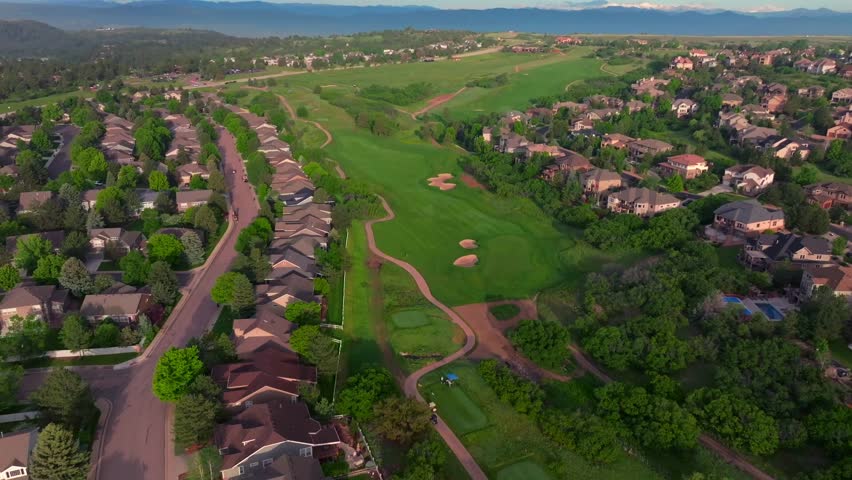 The Ridge North Castle Pines Village Golf Course aerial drone Colorado summer spring golfing Rocky Mountains front range neighborhood homes green grass fairway sand traps morning blue sky forward pan