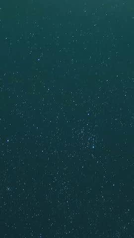 Astrophotography time-lapse capturing star trails over sand dunes, with the Milky Way rotating in the night sky, creating a mesmerizing and cosmic atmosphere—ideal for celestial visuals and desert.