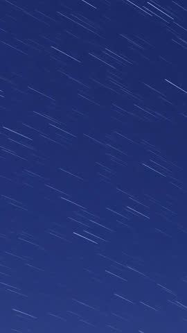 Astrophotography time-lapse capturing star trails over sand dunes, with the Milky Way rotating in the night sky, creating a mesmerizing and cosmic atmosphere—ideal for celestial visuals and desert.